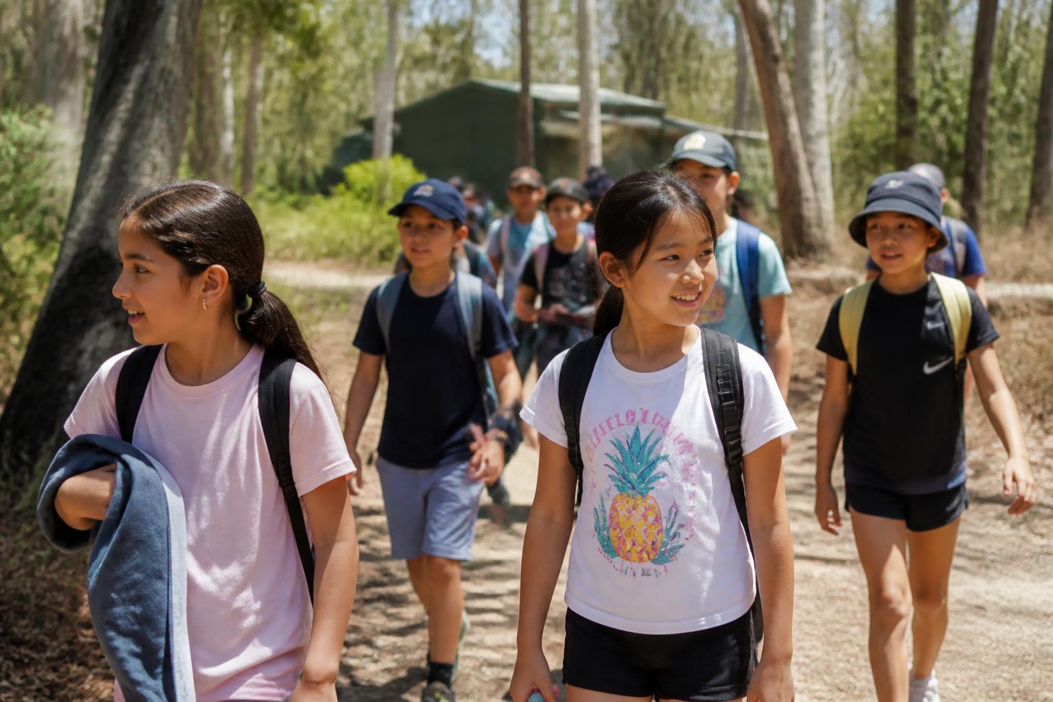 School children with backpacks walking together at camp