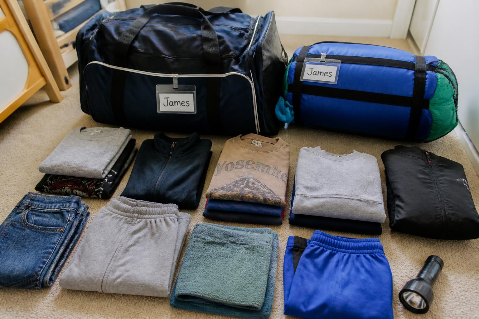 A child's labelled duffel and sleeping bag packed and ready for school camp